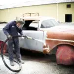 Central Alabama Mobile Sandblasting employee at work using automotive sandblasting on a vintage car