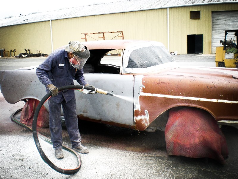 Central Alabama Mobile Sandblasting employee at work using automotive sandblasting on a vintage car