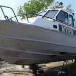 A large boat out of water showing the effects of marine sandblasting on the hull