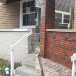 Before and after image of a red brick residential home after mobile sandblasting to remove the white paint from the brick